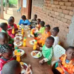 Élèves de l'école d'Okana dégustant le repas offert pour la Journée mondiale de l'alimentation