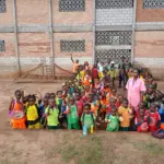Photo de groupe des élèves et enseignants dans la cour de l'école d'Okana
