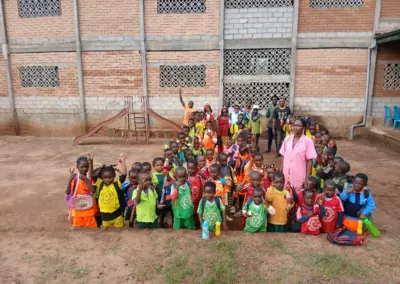 Photo de groupe des élèves et enseignants dans la cour de l'école d'Okana