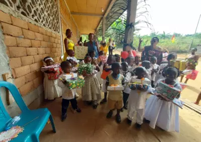 Élèves de maternelle d'Okana recevant leurs cadeaux de fin d'année