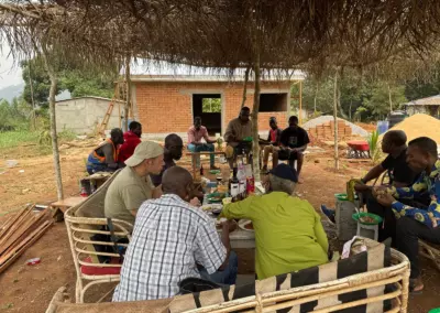 Habitants d'Ovangul rassemblés sous l'abri pendant les travaux de toiture